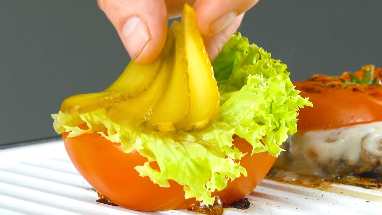 garnir la tomate de salade et de cornichon