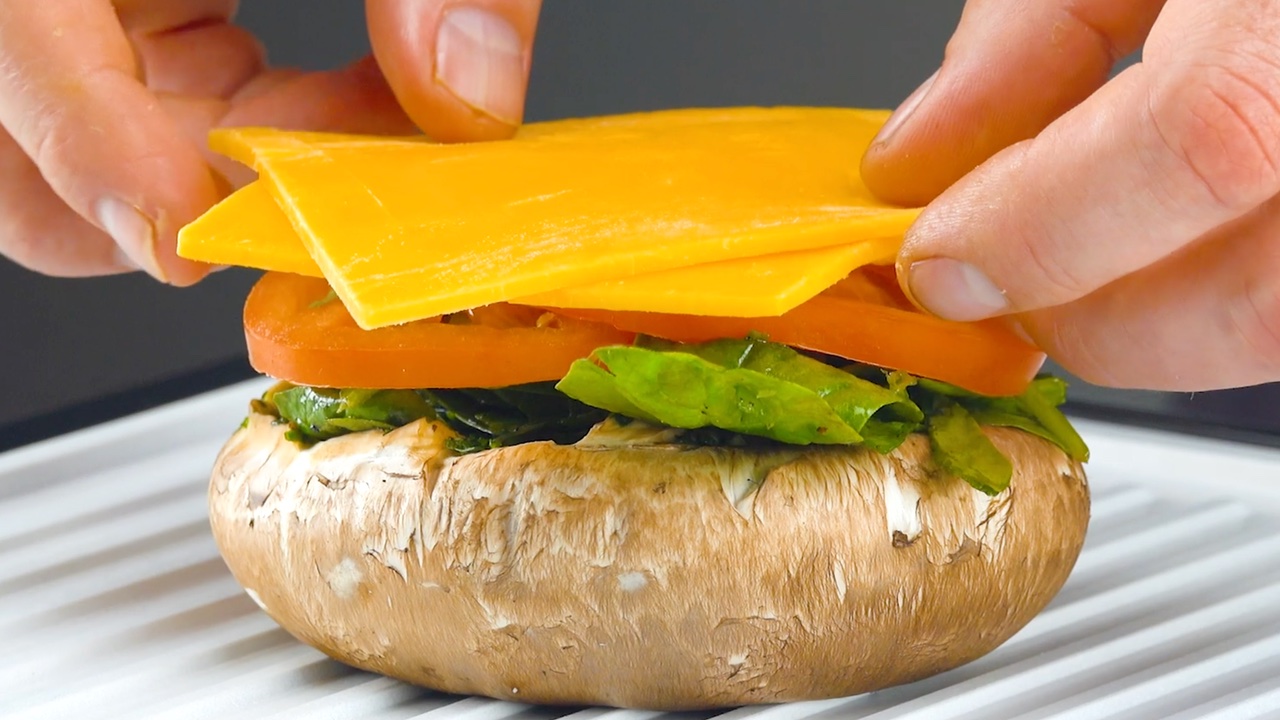 garnir le champignon de tomate et de fromage